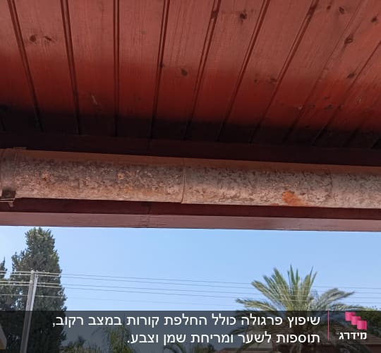 צינור מתכת חלוד מתחת לגג עץ
